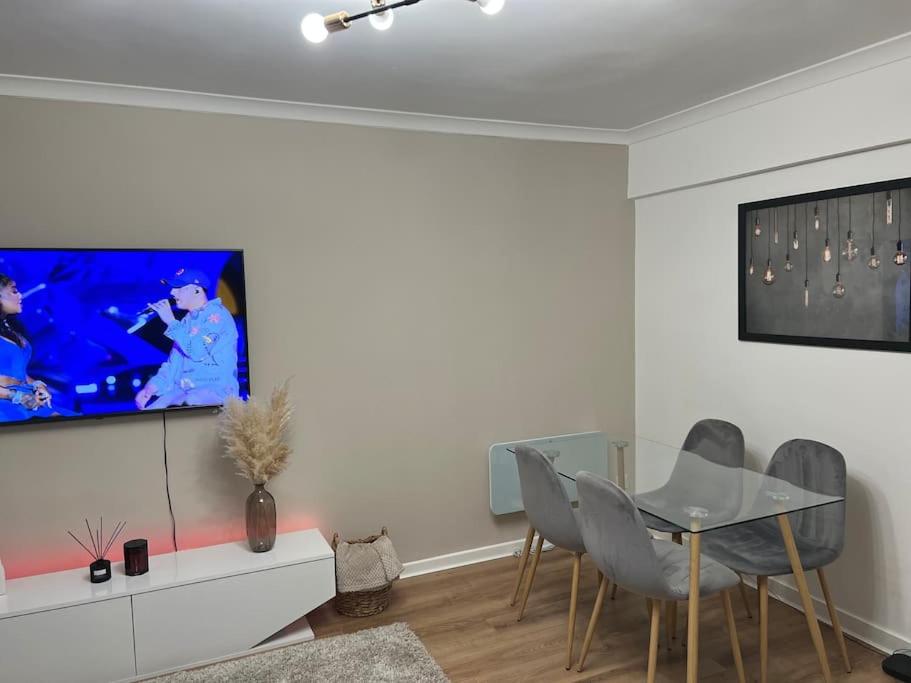 a living room with a table and a tv on a wall at Stunning 2-Bed Apart in the heart of Aberdeen* in Aberdeen