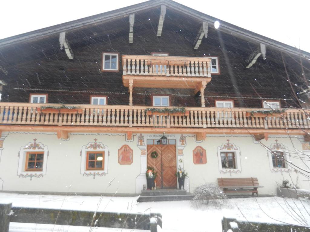 a house in the snow with a deck on it at Ferienwohnung Örgenbauer in Saalfelden am Steinernen Meer