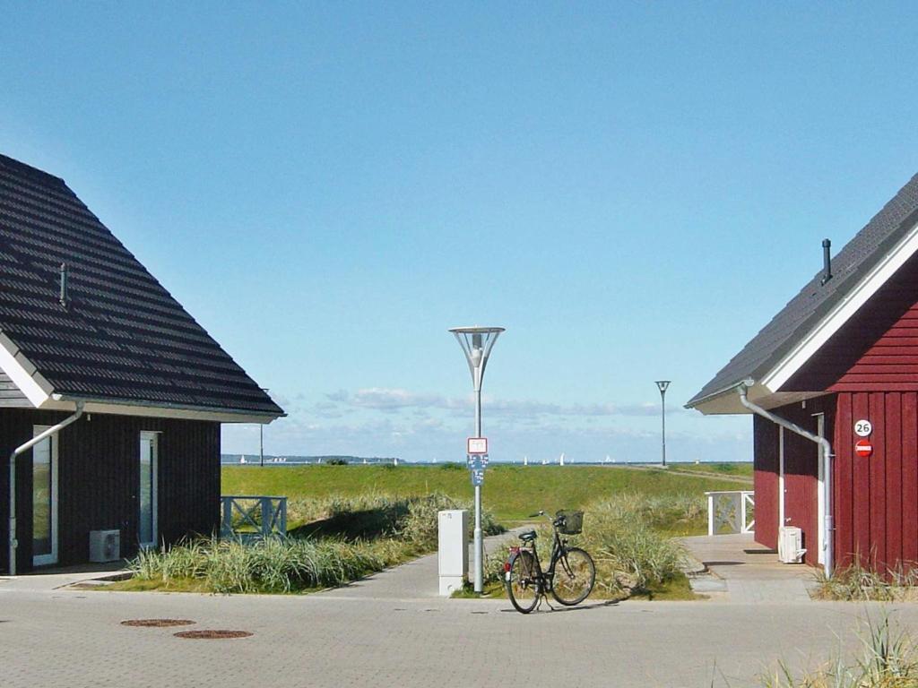 una bicicleta estacionada en un estacionamiento junto a dos edificios en 6 person holiday home in Wendtorf, en Wendtorf