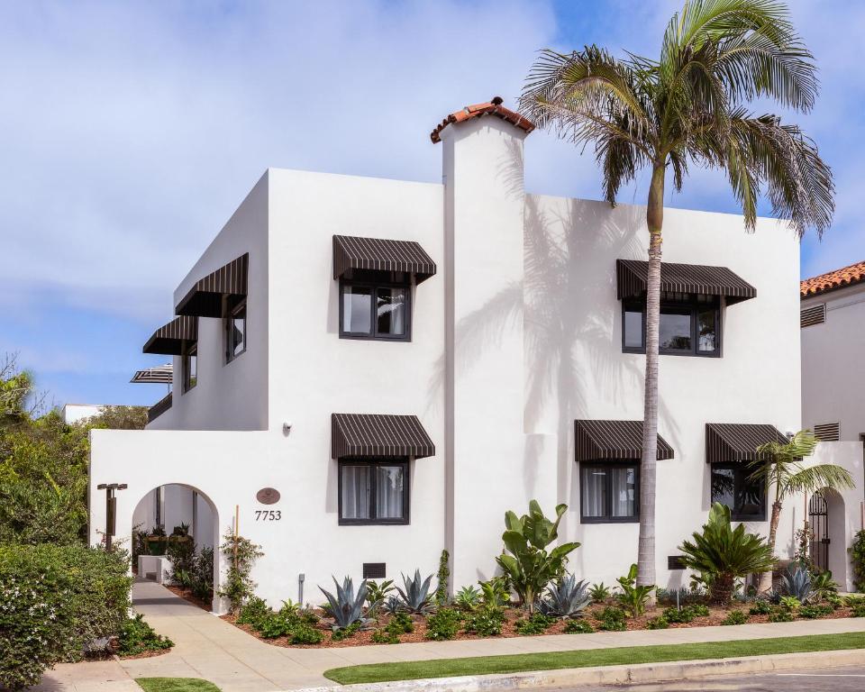 un bâtiment blanc avec un palmier en face dans l'établissement Orli La Jolla, à San Diego