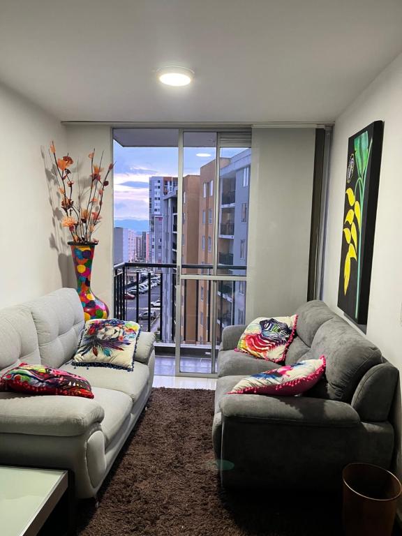una sala de estar con 2 sofás y una ventana grande en APARTAMENTO CONDINA PEREIRA, en Pereira