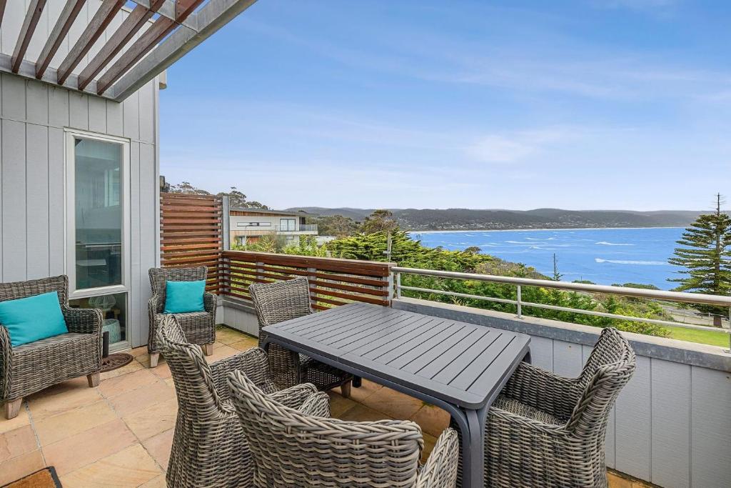 a table and chairs on a balcony with a view of the water at Point Grey Apartment 2 in Lorne