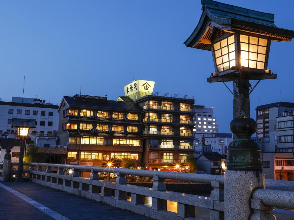 un edificio con luci di fronte a un ponte di Ohashikan a Matsue