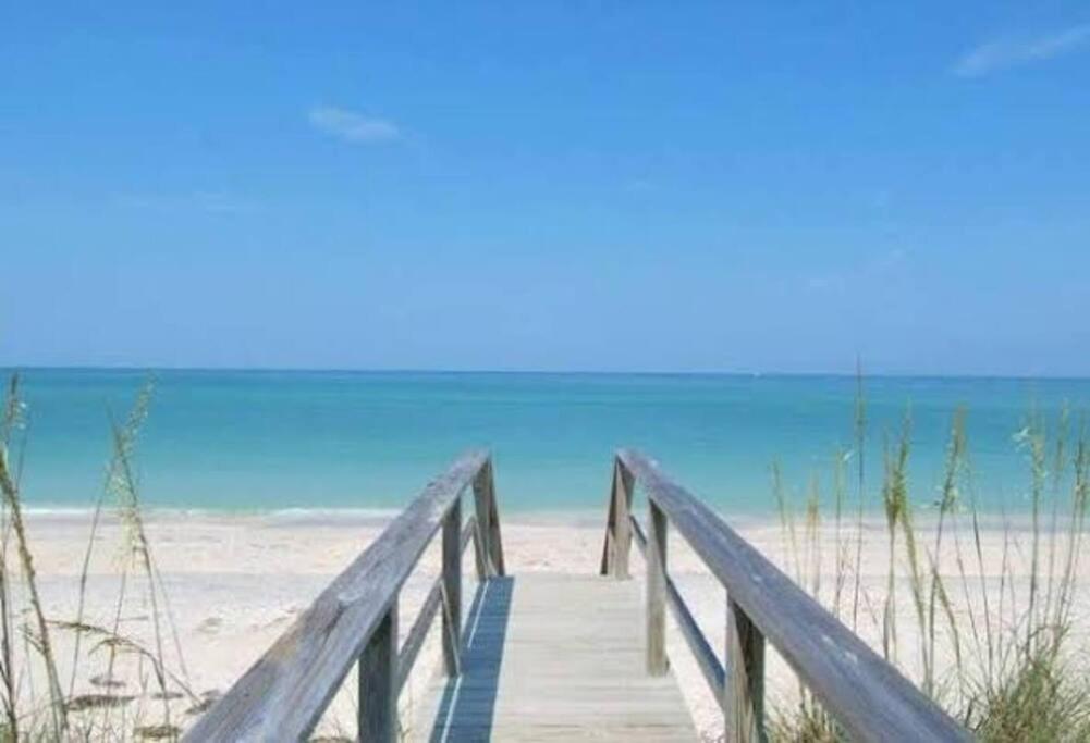 a wooden pathway to the beach with the ocean in the background at Charming Studio Unit Across from Lido Key Beach in Sarasota