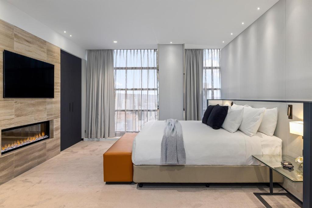 um quarto com uma cama grande e uma lareira em Peppers Waymouth Hotel em Adelaide