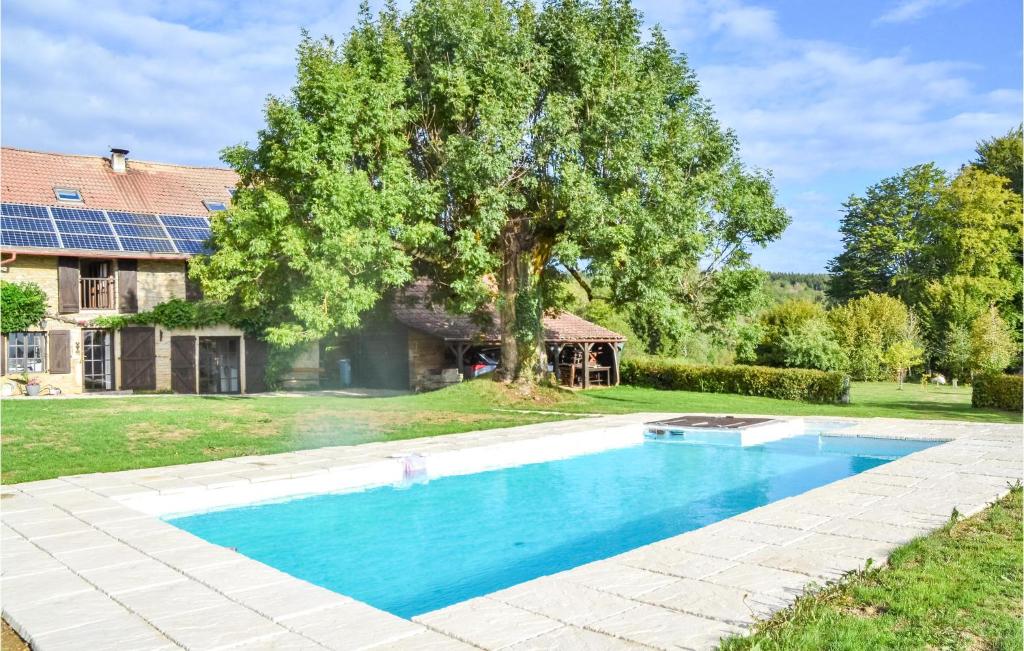 a swimming pool in front of a house with a tree at Beautiful Home In Loisia With Wifi 