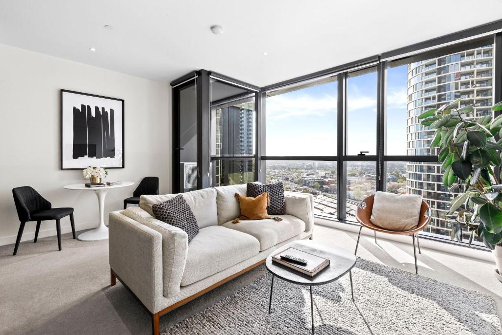 sala de estar con sofá y ventana grande en Luxuria Apartments - Fulton Lane, en Melbourne