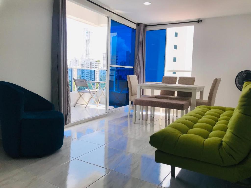 ein Wohnzimmer mit einem Sofa, einem Tisch und Stühlen in der Unterkunft Sotavento Suites in Cartagena de Indias
