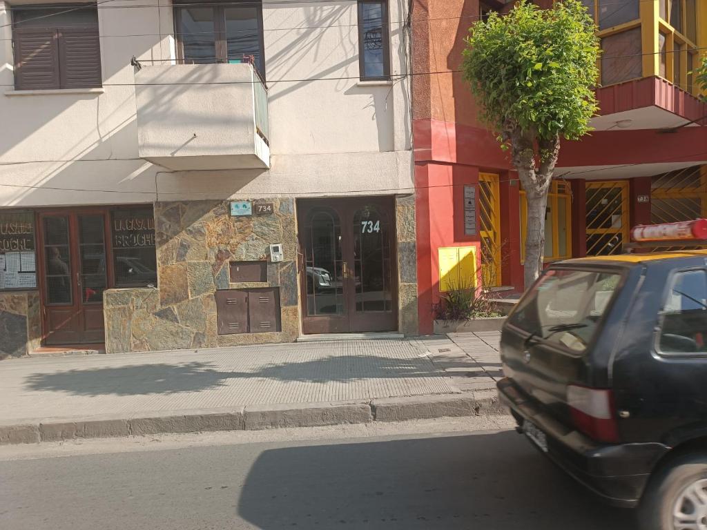 un'auto parcheggiata in una strada di fronte a un edificio di Independencia 734, Dpto 11 a San Salvador de Jujuy