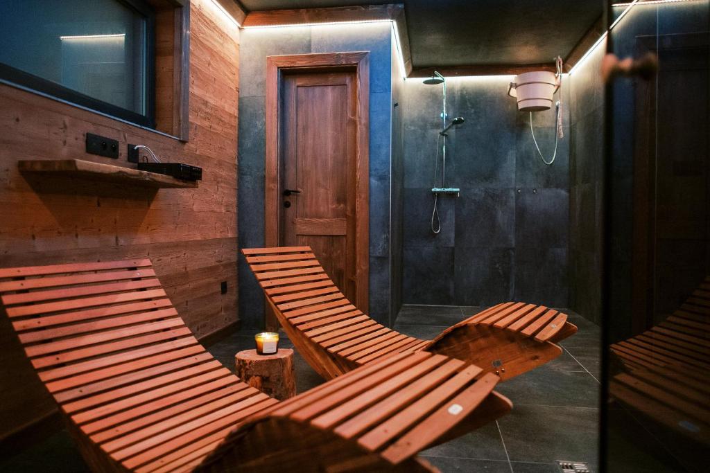 two wooden chairs in a bathroom with a shower at Chalet Zuberec in Zuberec
