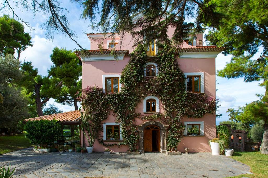 una casa rosa con hiedra creciendo en ella en Capo Santa Fortunata, en Sorrento