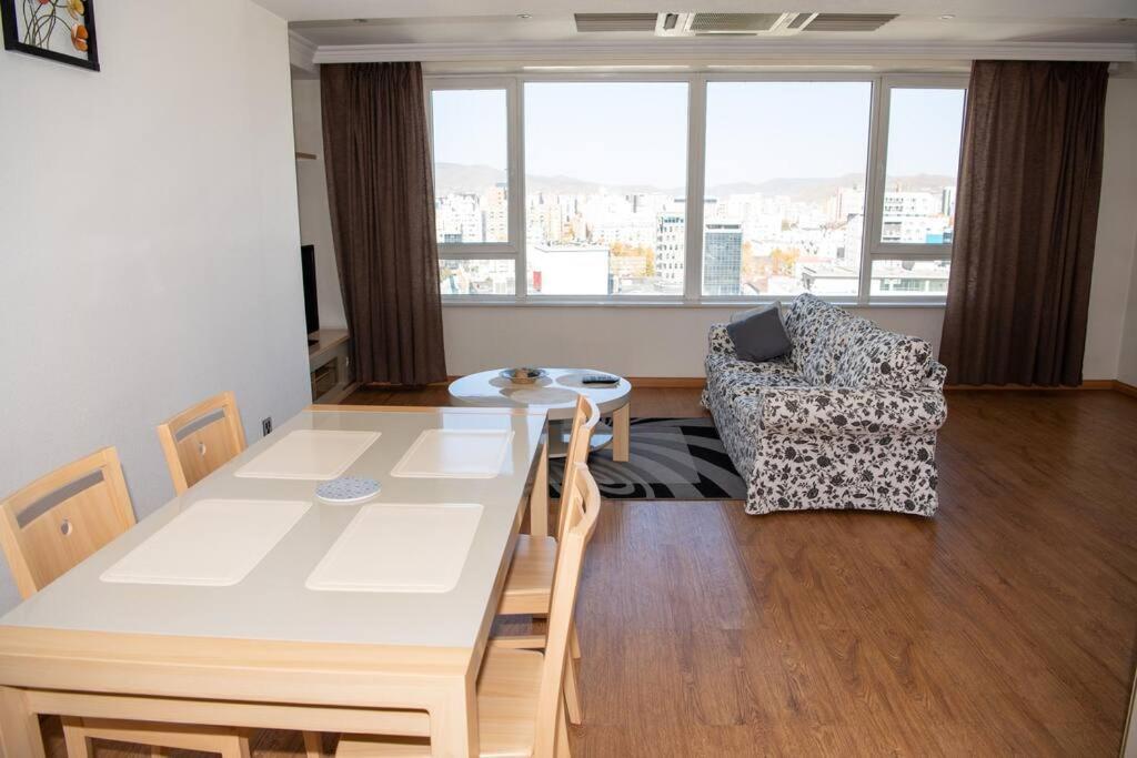 ein Wohnzimmer mit einem Esstisch und einem Sofa in der Unterkunft Lovely 2 BR unit with city view in Ulaanbaatar