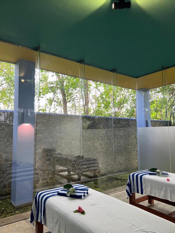 a room with two beds and a glass wall at Buckingham Place in Tangalle