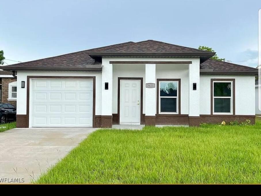 a house with a garage and a green lawn at Home Sweet Home in Fort Myers