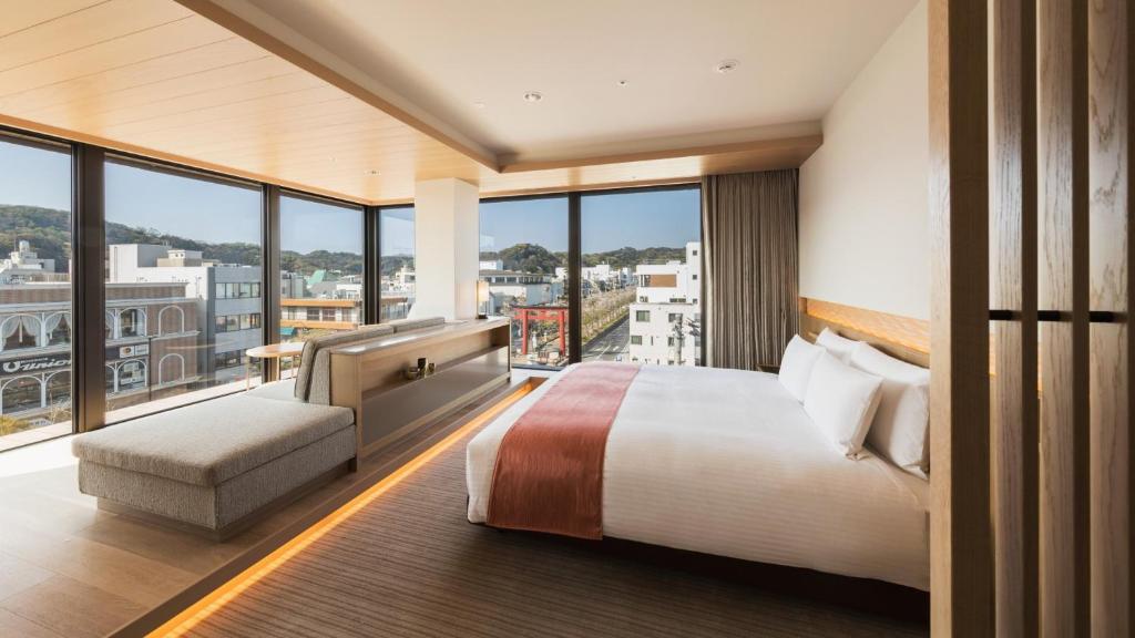 een hotelkamer met een bed en een groot raam bij Hotel Metropolitan Kamakura in Kamakura