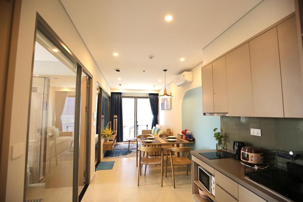 a kitchen with a table and a dining room at Luxury The Song Vung Tau Apartment Homestay in Vung Tau