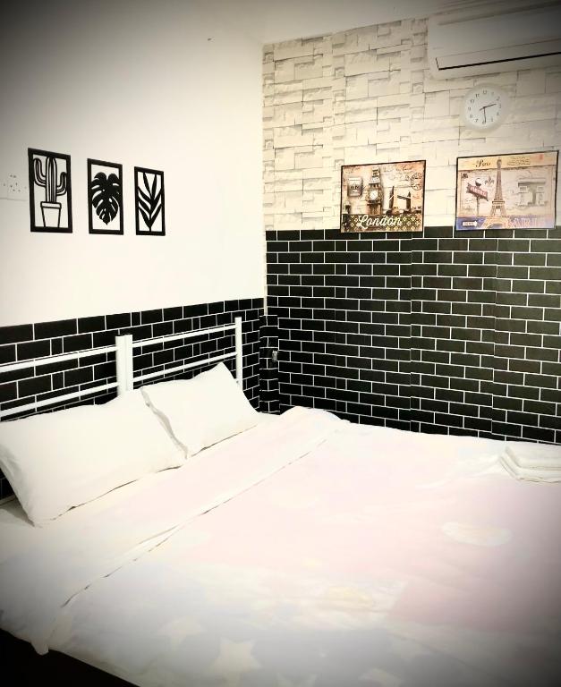 a white bed in a room with a brick wall at Triang homestay 2 in Kampong Kerayong