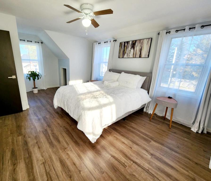 1 dormitorio con cama blanca y ventilador de techo en Cochrane Diggs, en Cochrane