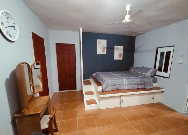 1 dormitorio con 1 cama y reloj en la pared en Affordable Staycation Home for 2-3 People! en Dauin