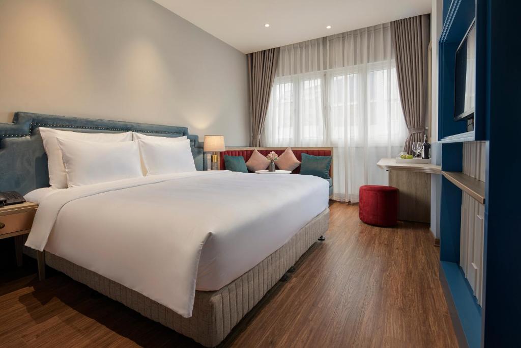 duże białe łóżko w pokoju hotelowym z oknem w obiekcie HANOI FLORA HOTEL w mieście Hanoi