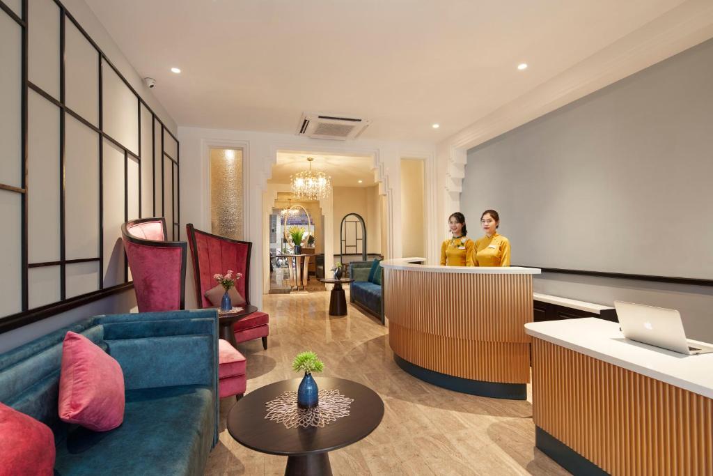 two people standing at a bar in a hotel lobby at HANOI FLORA HOTEL in Hanoi