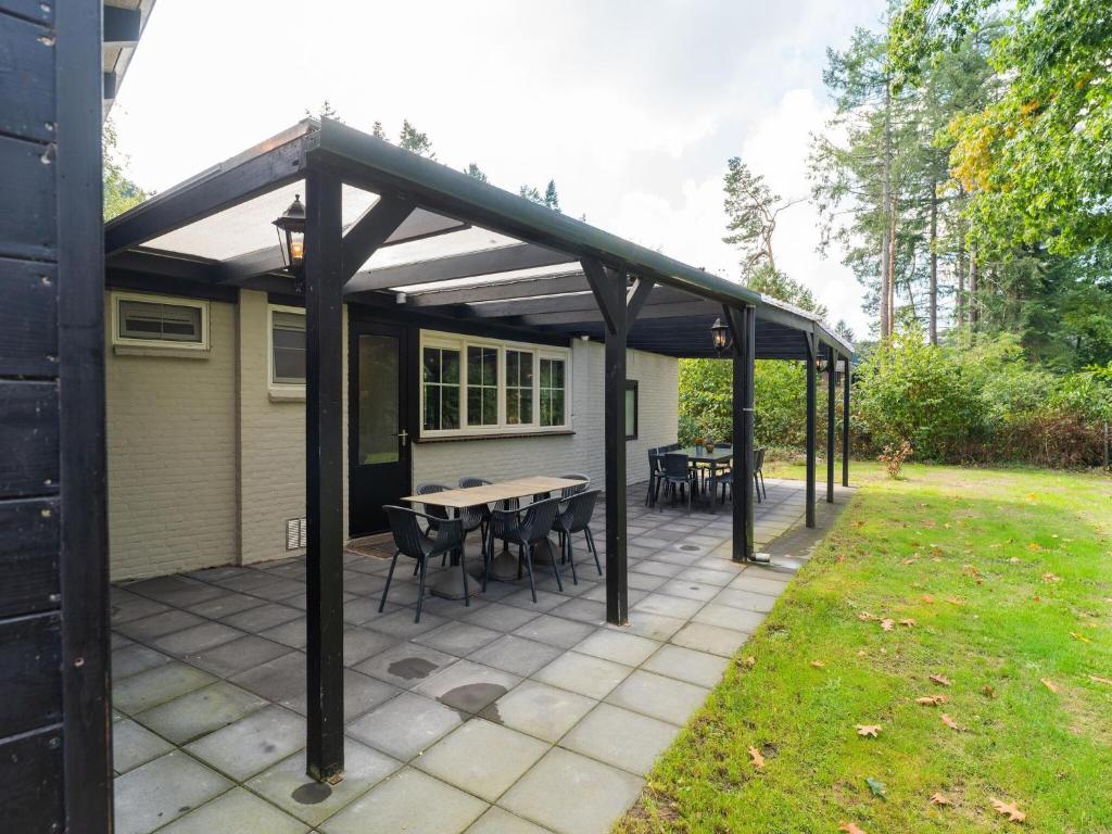 a pergola with a table and chairs on a patio at Holiday Home in Gelderland near Den Bramel in Lochem