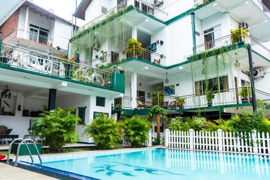 a hotel with a swimming pool in front of a building at Kandy Riverside Villa in Kandy