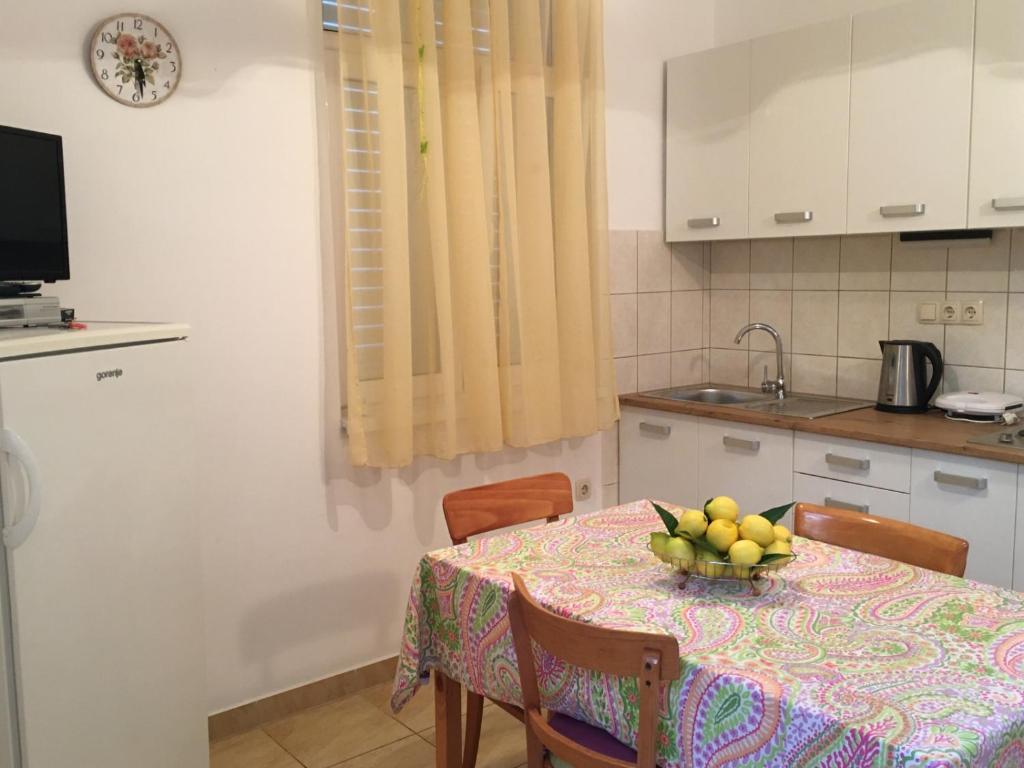 a kitchen with a table with a bowl of fruit on it at Apartment in Slatine with terrace, air conditioning, WiFi, washing machine (4782-3) in Slatine