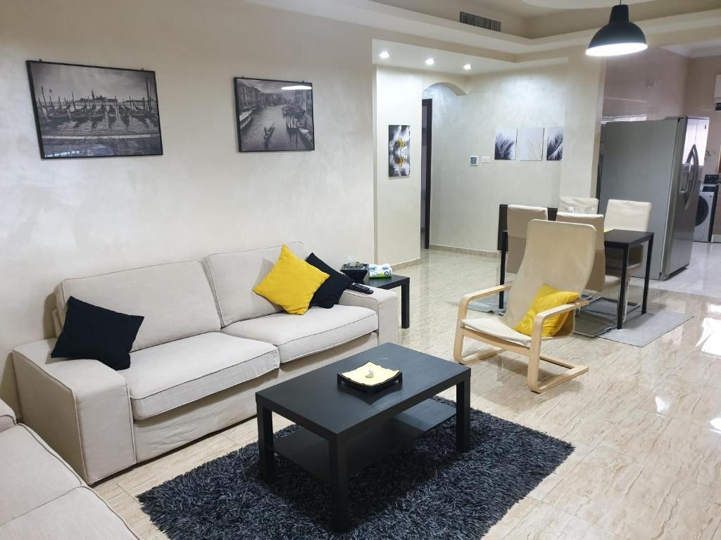 a living room with a couch and a table at Dair Ghbar 2-bedrooms unit in Amman
