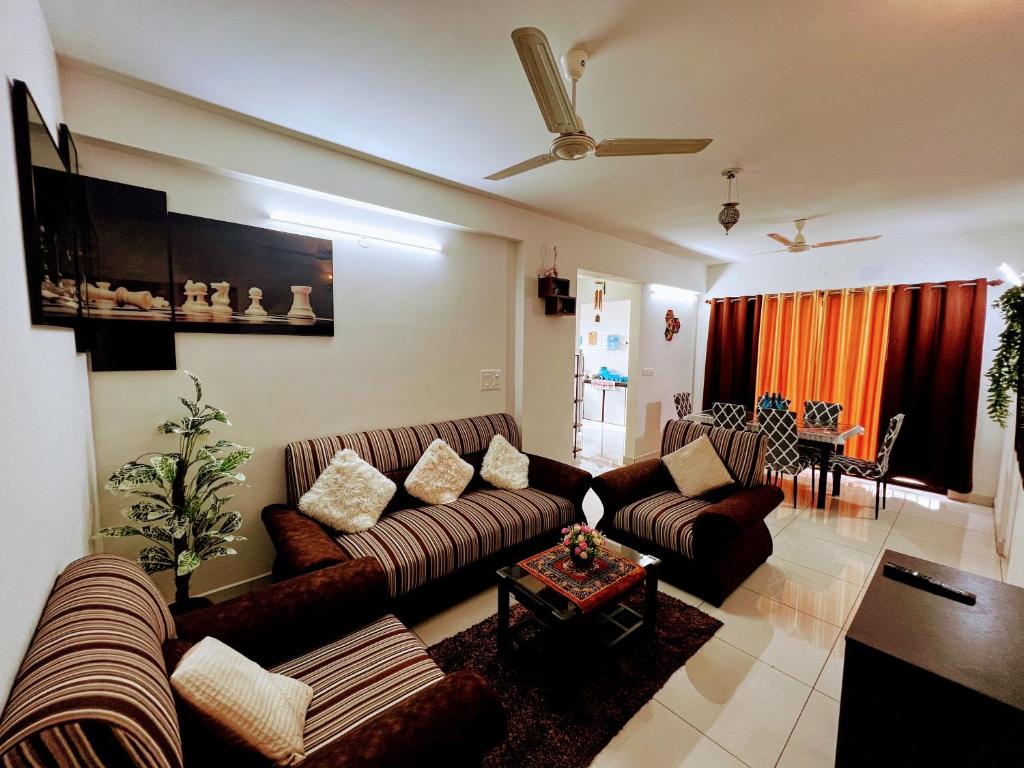 een woonkamer met een bank en een tafel bij Cozy 2BHK condo surrounded with greenery. in Mangalore