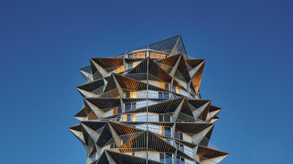 un edificio alto con balcones en un cielo azul en A Place To Hotel Esbjerg en Esbjerg