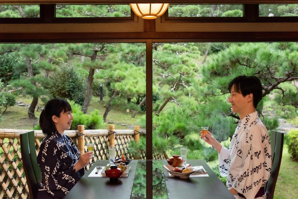two women sitting at a table in front of a window at Hotel Hagoromo in Shizuoka