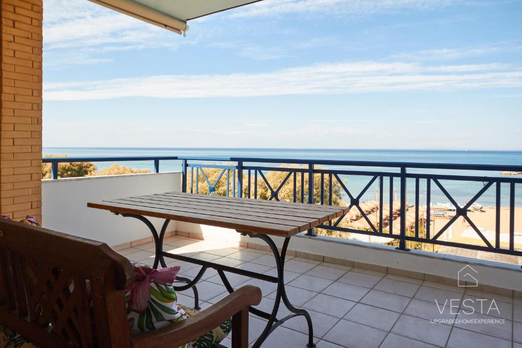 een balkon met een tafel en uitzicht op de oceaan bij Thalassophile Neoi Epivates, Vesta Philoxenia in Neoi Epivatai