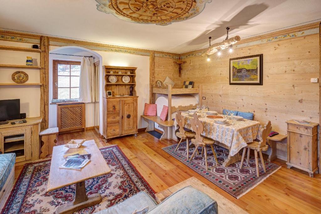 a dining room with a table and a tv at Villa Marianna - Stayincortina in Cortina dʼAmpezzo