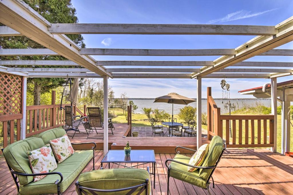 a deck with chairs and a table with a view of the ocean at Gloucester Retreat with Backyard Oasis and Pier! in Gloucester