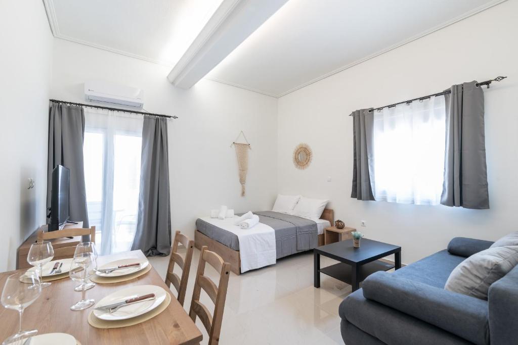 Blue Riviera villas & suites - Alimos 2 في أثينا: غرفة معيشة مع سرير وطاولة طعام