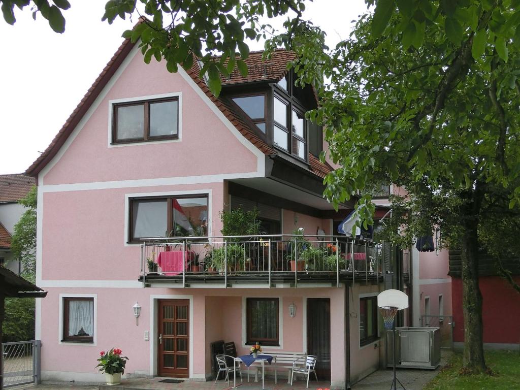 Casa de color rosa con balcón en Ferienwohnung Singer, en Schnaittach