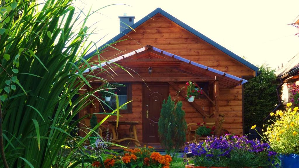 drewniany domek z kwiatami przed nim w obiekcie Cztery Pory Roku - Domek 
