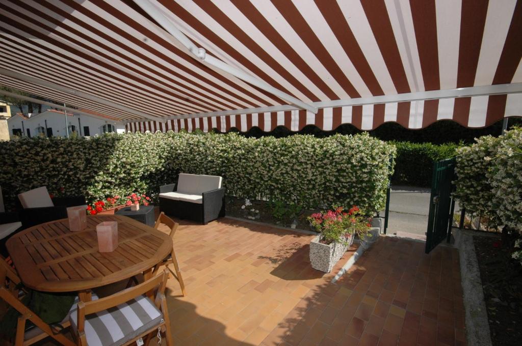 une terrasse avec un parasol, une table et des chaises dans l'établissement Oleandro, à Marina di Campo