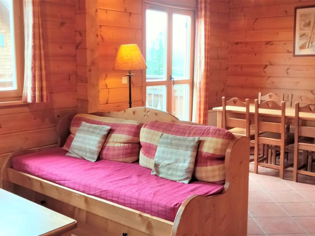 een bed in een kamer met houten wanden en een raam bij Chalet La Joue du Loup, 3 pièces, 6 personnes - FR-1-504-651 in Le Dévoluy