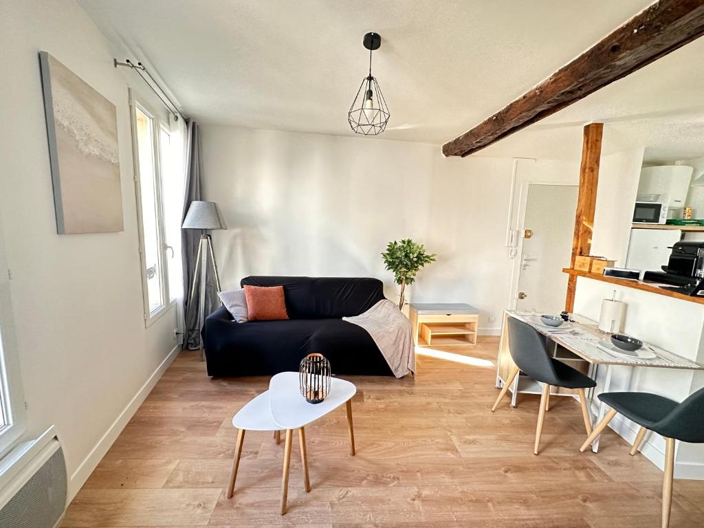 a living room with a couch and a table at Home Up Pontoise in Pontoise