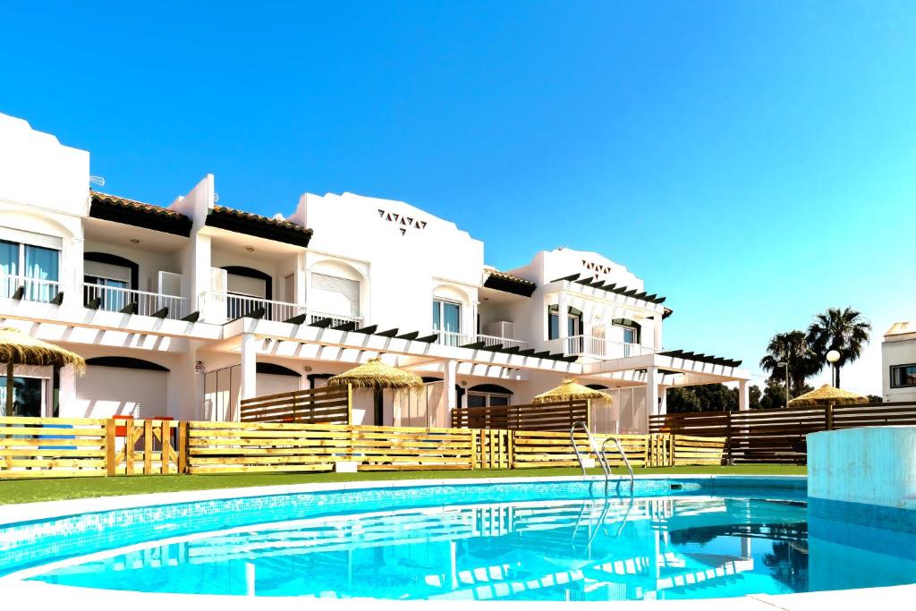a hotel with a swimming pool in front of a building at Gran Villa Roquetas Beach & Golf Playa Serena in Roquetas de Mar