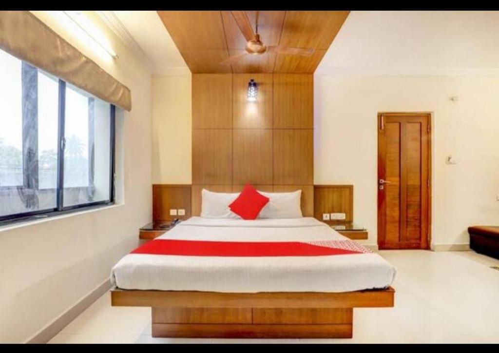 a bedroom with a large bed with red pillows at HOTEL MALABAR PLAZA in Chennai