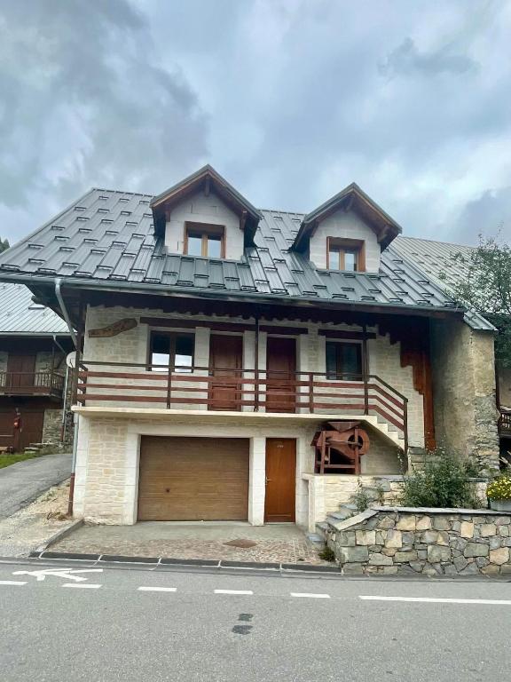 une maison avec un toit en gambrel et un garage dans l'établissement Deux appartements individuels de 8 personne à 200 mètres des remontées mécaniques au centre du village, à Saint-Sorlin-dʼArves