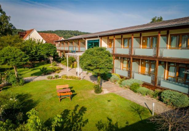 a building with a yard with a bench in front of it at Hotel Locker & Legere in Sankt Ruprecht an der Raab