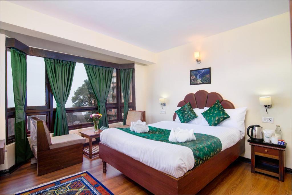 a bedroom with a large bed and a large window at Muscatel BhumSang - 200 Mts from Mall Road in Darjeeling