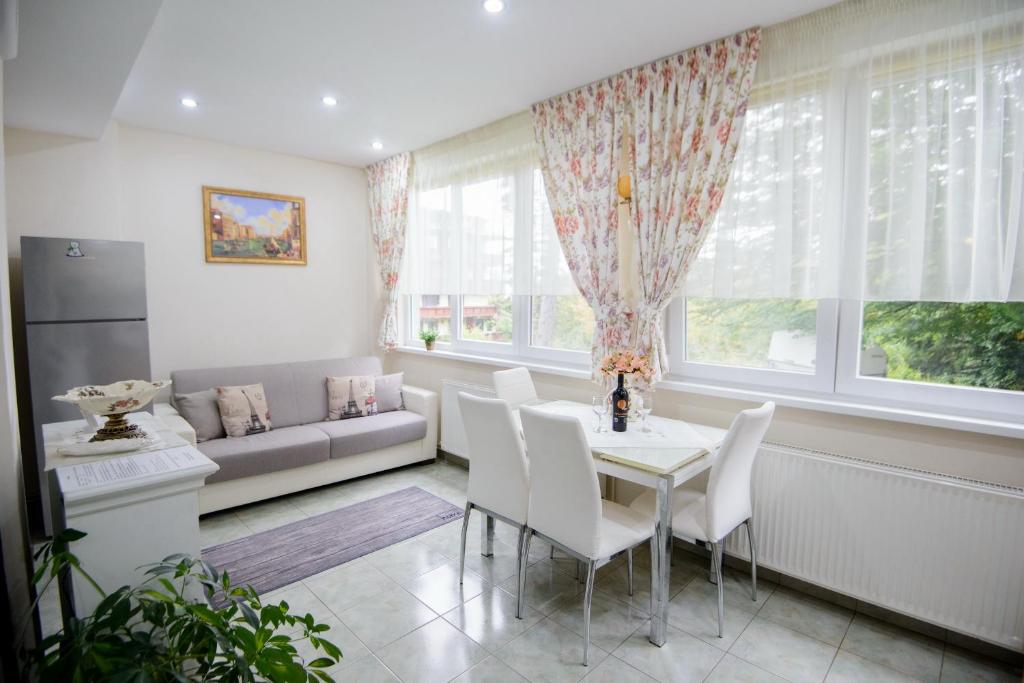 a living room with a table and chairs and a couch at Apartament Eliza in Poiana Brasov