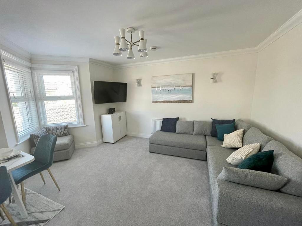 a living room with a couch and a tv at Exquisite apartment, stone throw from the beach in Bournemouth