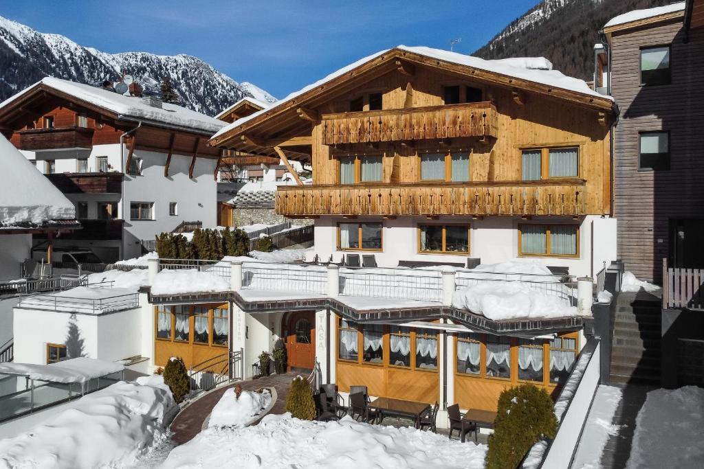 a large building with snow on the roof at Pension Tasa in Valles