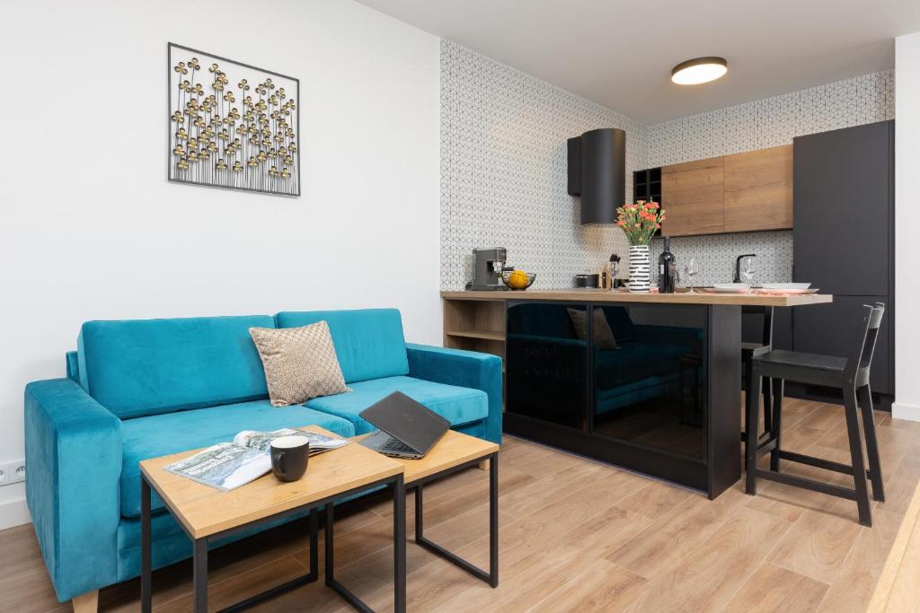 un soggiorno con divano blu e una cucina di Śródmieście Warsaw Muranów Apartments with Parking by Renters a Varsavia